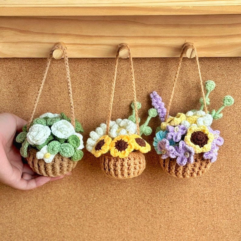 Crocheted hanging plant pots with colorful flowers on a wooden shelf